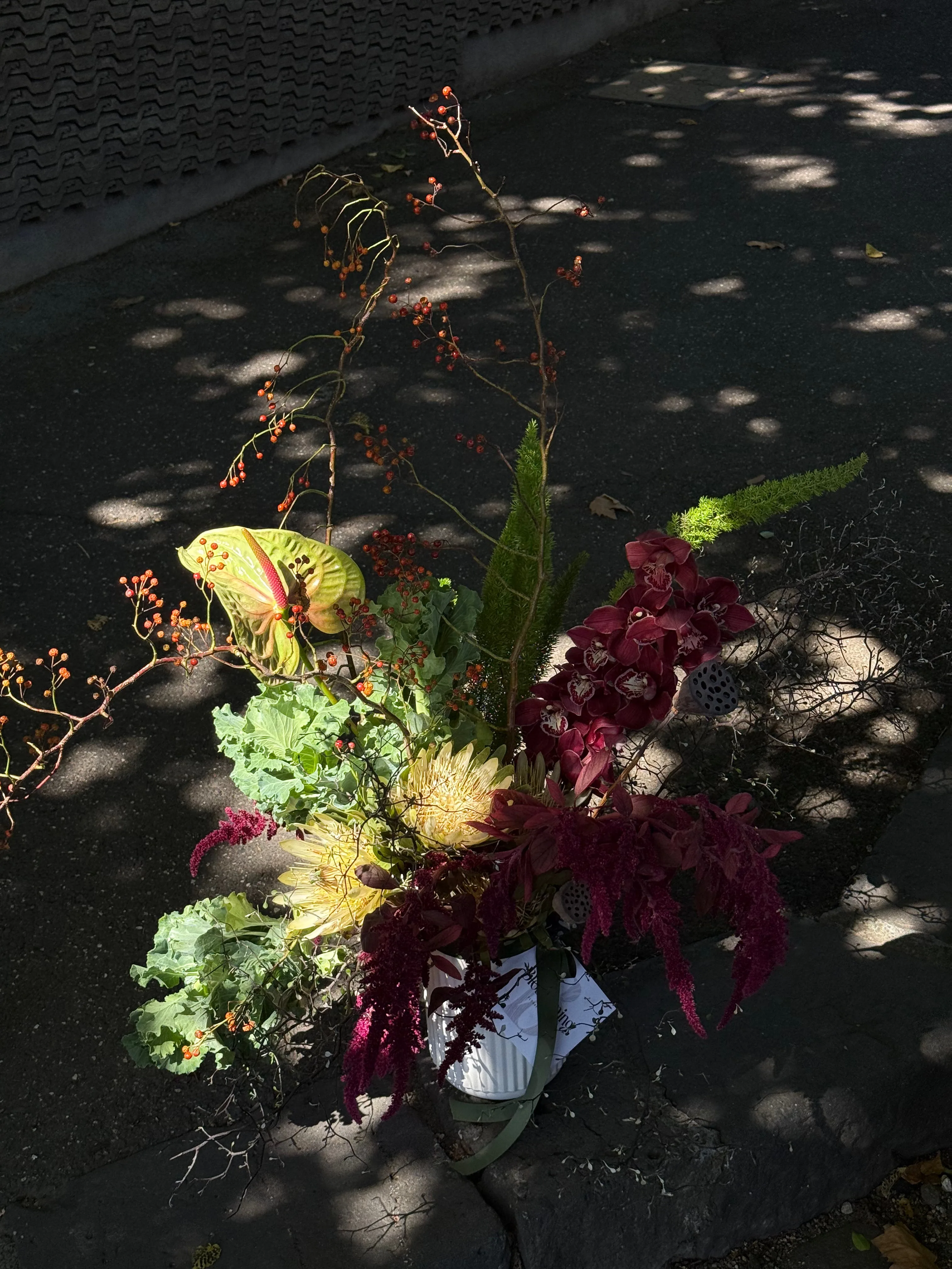 Wild autumnal sculptural arrangement — king protea, burgundy cymbidium, green anthurium — Blossoming Couture